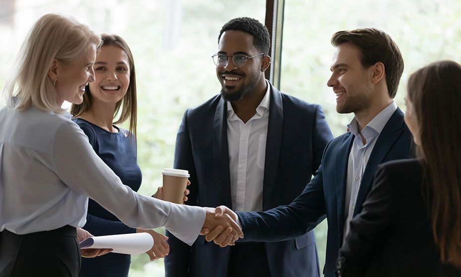 A group of business people smiling and shaking hands with the North team