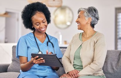 woman caregiver showing home healthcare patient some info on a tablet