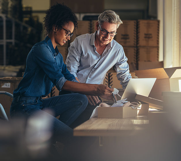 Two business owners reviewing contents of a package they order