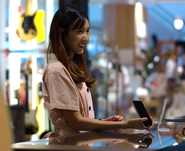 A customer showering her rewards account on her phone to a store clerk