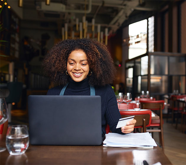 A fine dining business owner looking over business reports on her laptop thanks to North POS systems