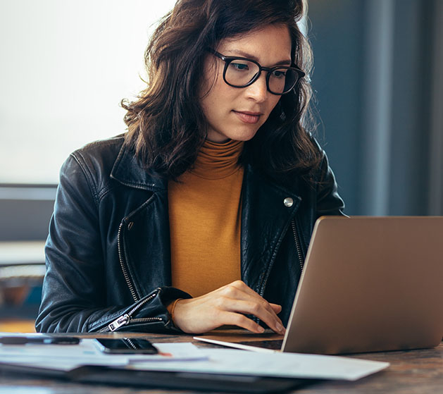 A female web developer working on her laptop reviewing North POS software