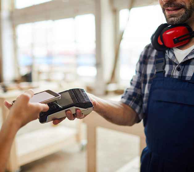 A contractor using Tap to Pay to receive payment from a customer's phone