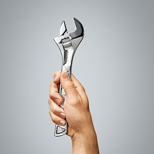 A hand holding a wrench representing the contractors industry