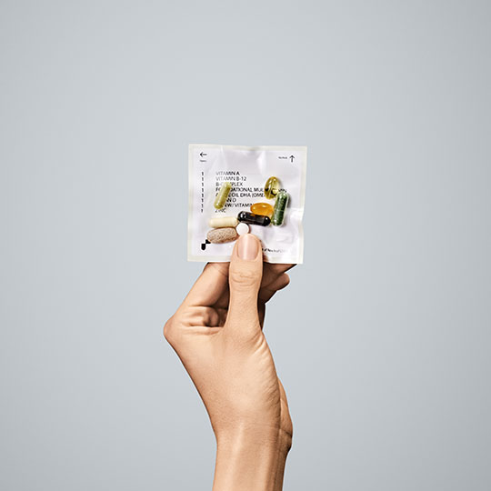 A hand holding a packet of pills representing the online pharmacy industry